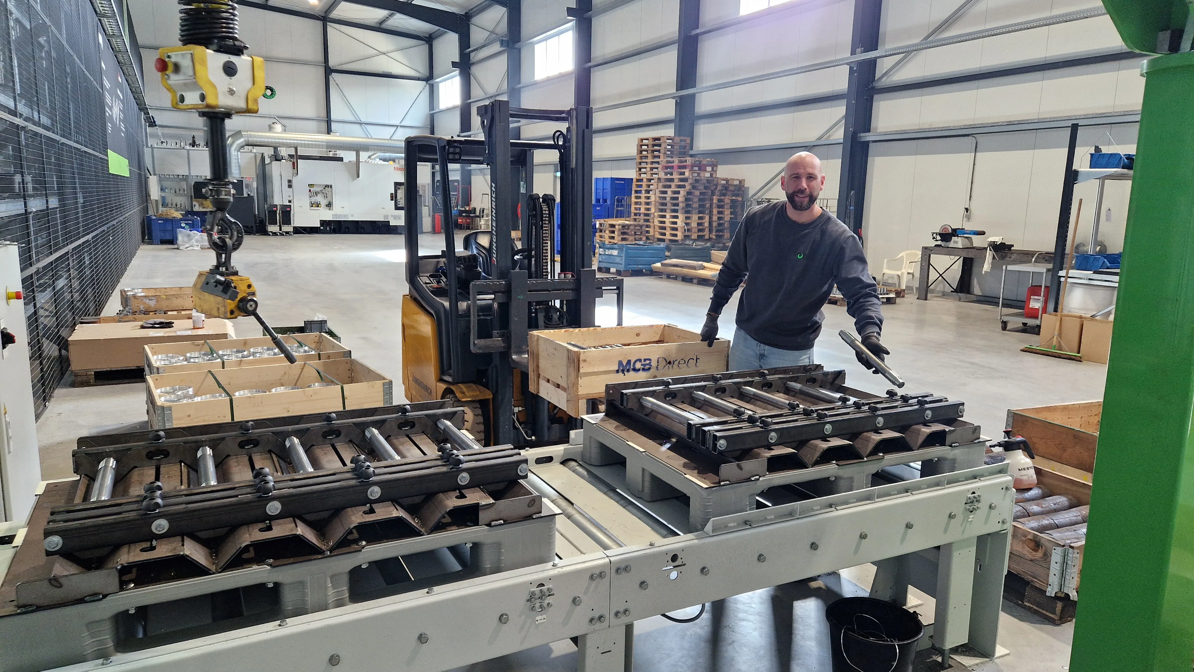 Logistics employee at the infeed conveyor with material pallets