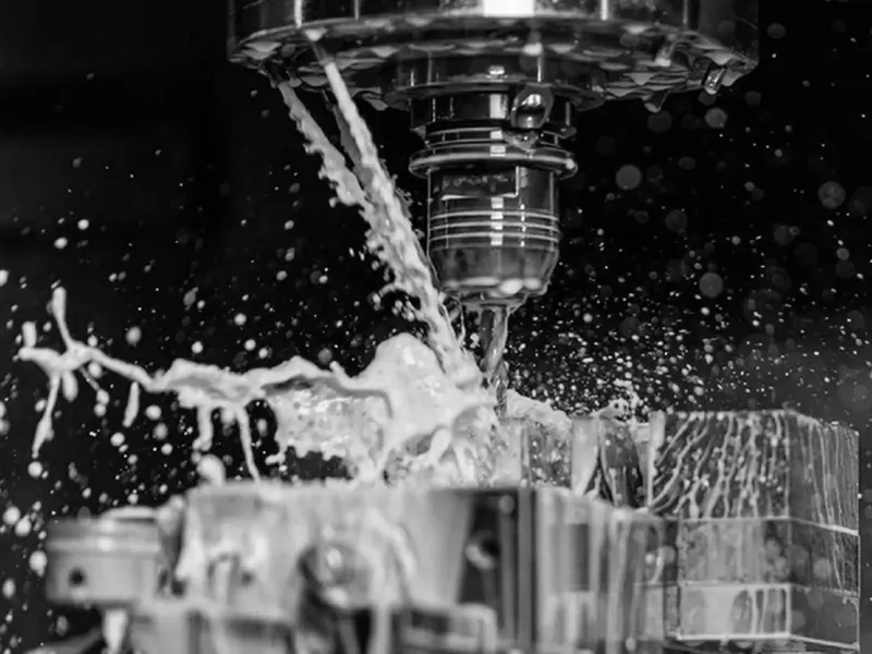 Milling cutter machining a workpiece while coolant splashes