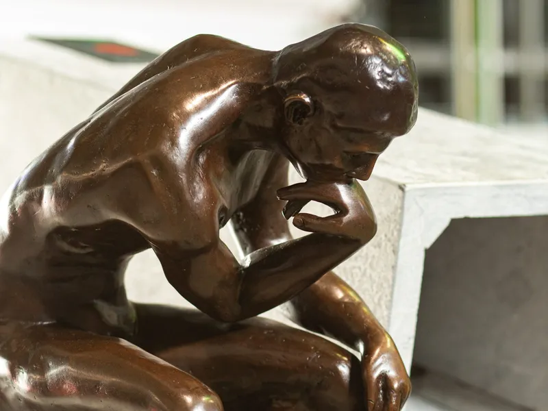 A bronze statuette of The Thinker by Rodin at the entrance of RODIN machining